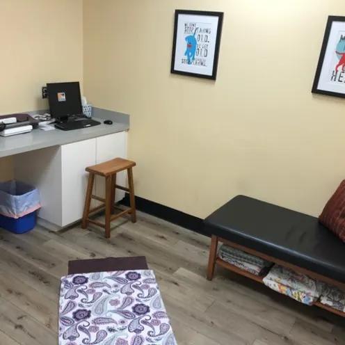 Calabasas Animal Clinic Exam Room that has a small leather cushioned bench for the client to sit in and picture frames mounted on the wall